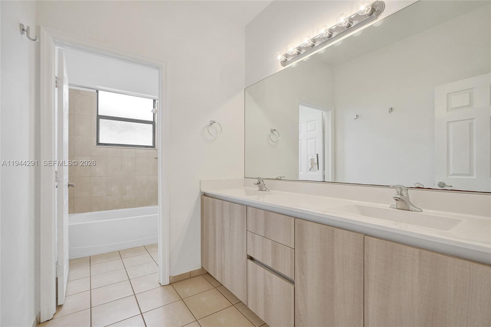 3504 West 94th Street Hialeah, FL 33018 - Photo 40 of 61 a bathroom with a double vanity sink a mirror and a bathtub