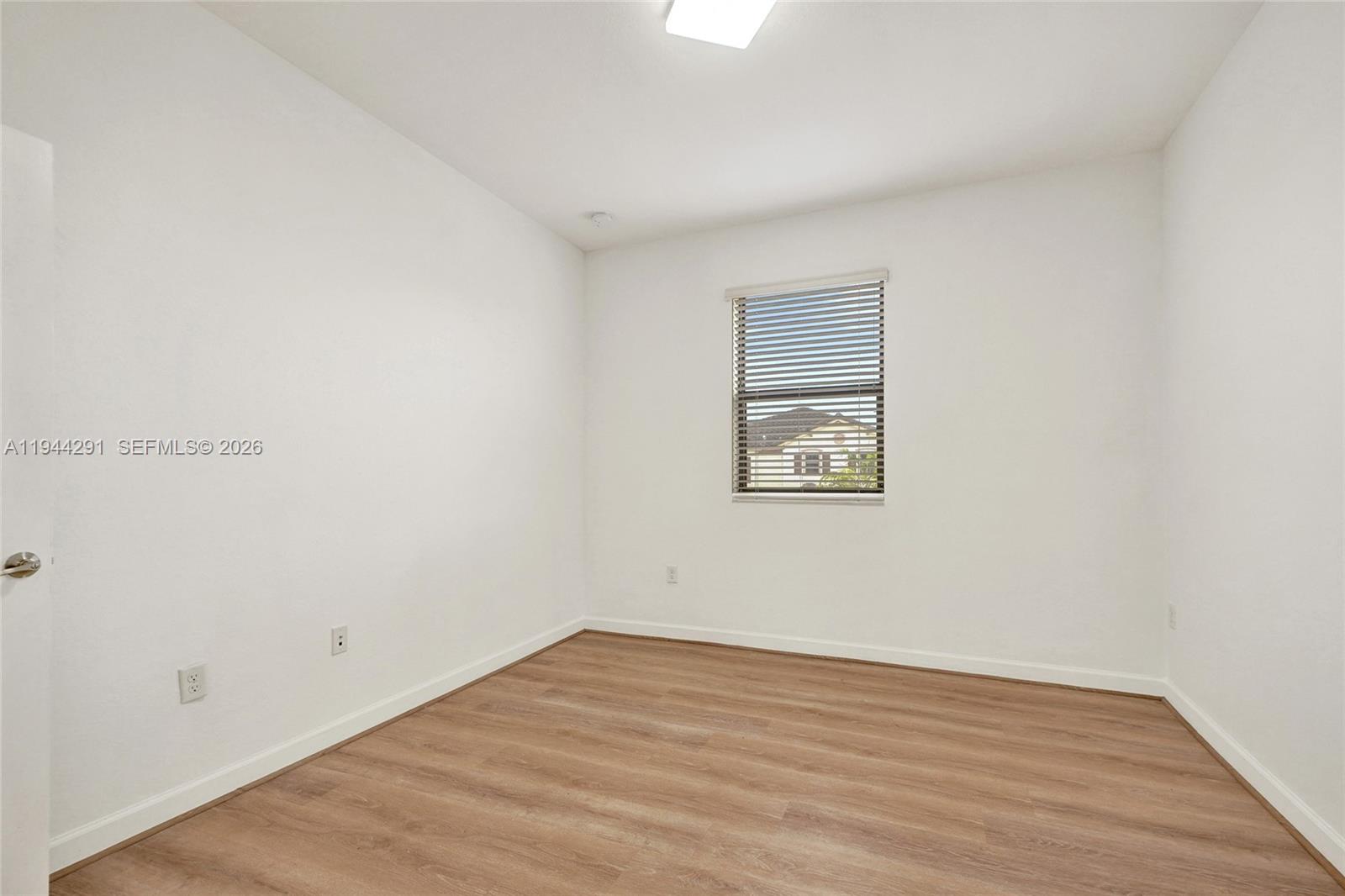 3504 West 94th Street Hialeah, FL 33018 - Photo 54 of 61 an empty room with wooden floor and windows