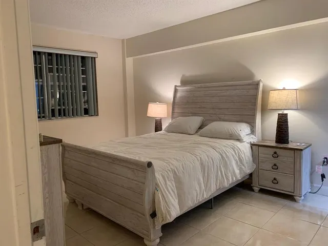a bedroom with a bed and a lamp on the dresser