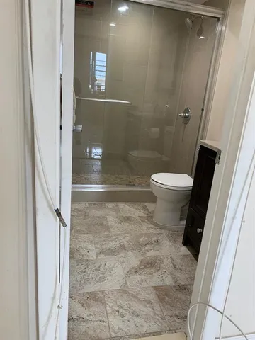 a bathroom with a toilet and a shower
