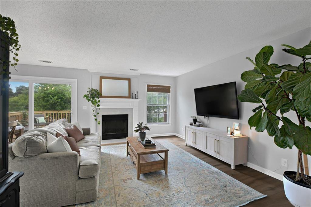 a living room with furniture a fireplace and a flat screen tv
