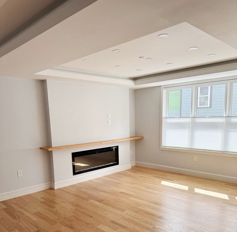 17 Fremont Street, Unit 1 Somerville, MA 02145 - Photo 3 of 7 a view of empty room with wooden floor and fan