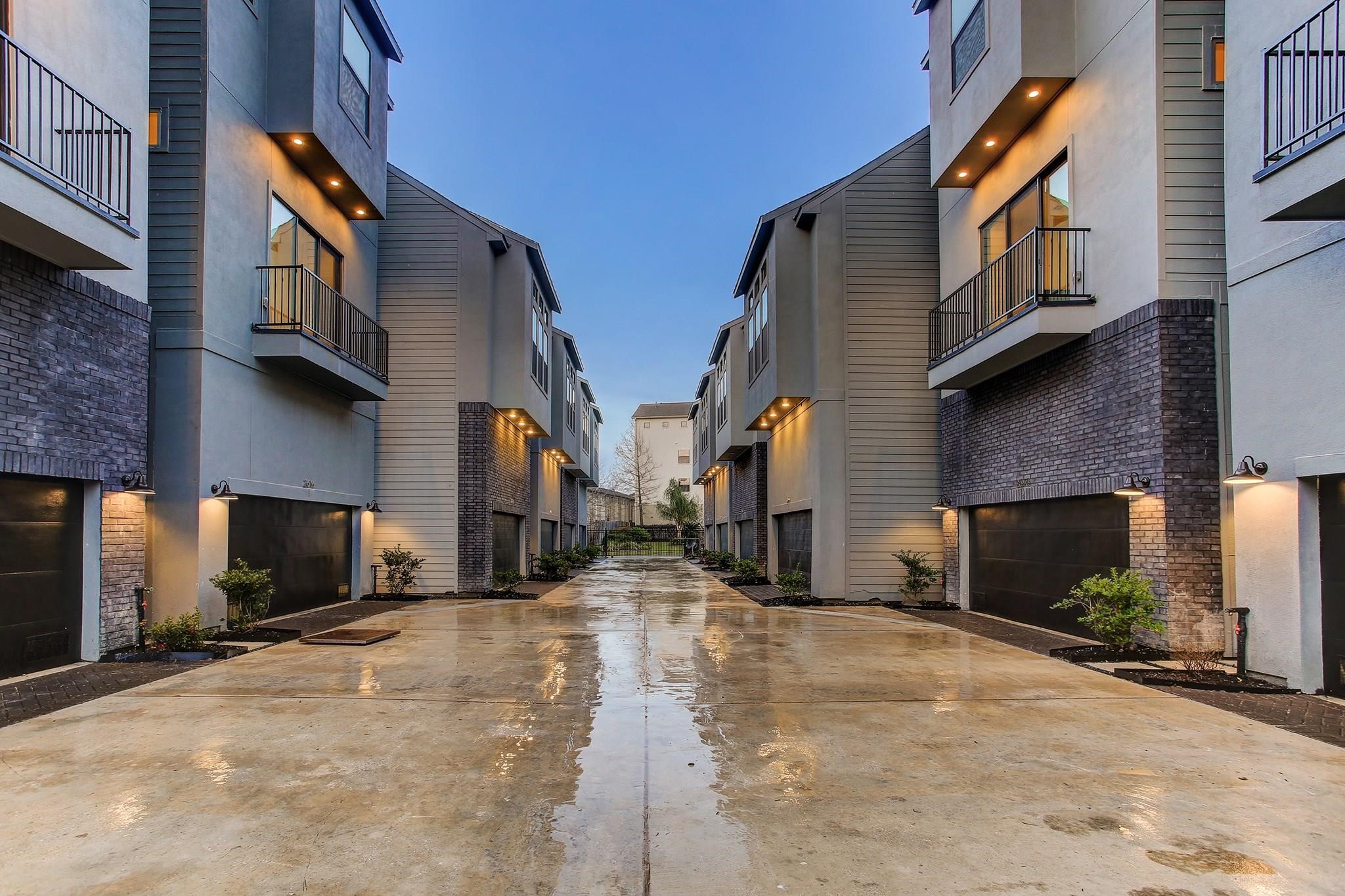 2616 Riverside Drive, Unit K Houston, TX 77004 - Photo 29 of 31 Modern townhouse complex with a clean, well-lit driveway. The buildings feature contemporary architecture with balconies and sleek finishes.