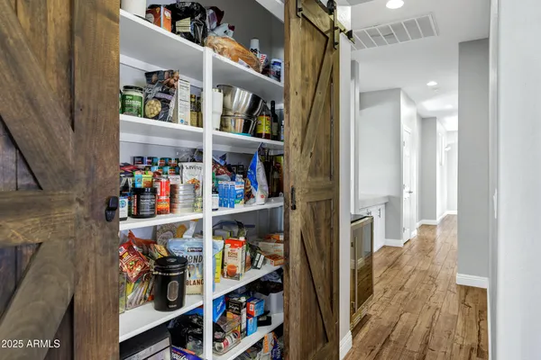 a view of a hallway with wooden floor and cabinet