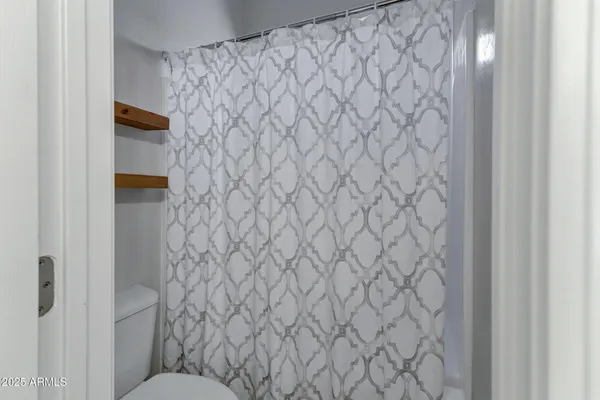 a bedroom with a large bed a chandelier and windows