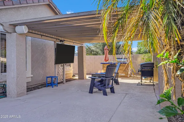 a patio with table and chairs and potted plants