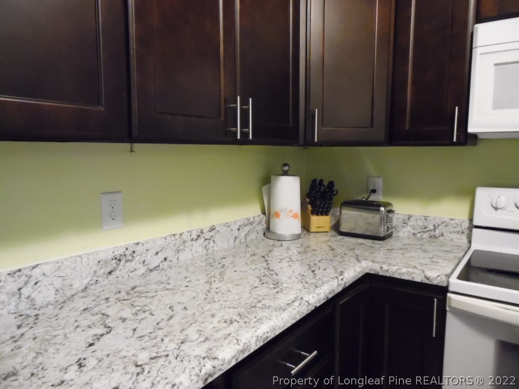 6799 Faircloth Bridge Road Stedman, NC 28391 - Photo 11 of 25 a kitchen with granite countertop white cabinets and a stove