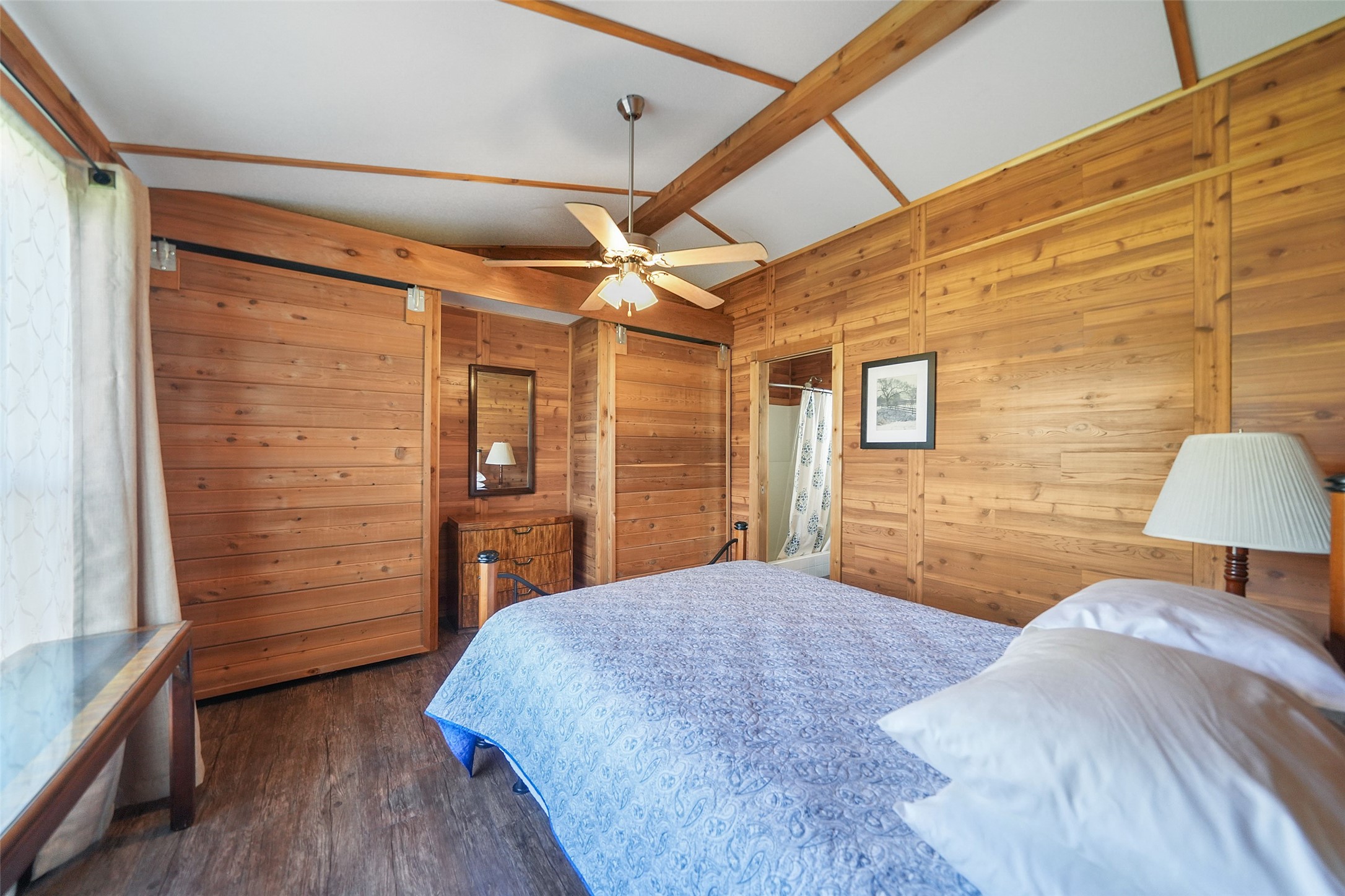 26250 A Riley Road Waller, TX 77484 - Photo 48 of 50 Cabin bedroom with sliding closet doors, warm wood finishes, and a vaulted ceiling with exposed beams.
