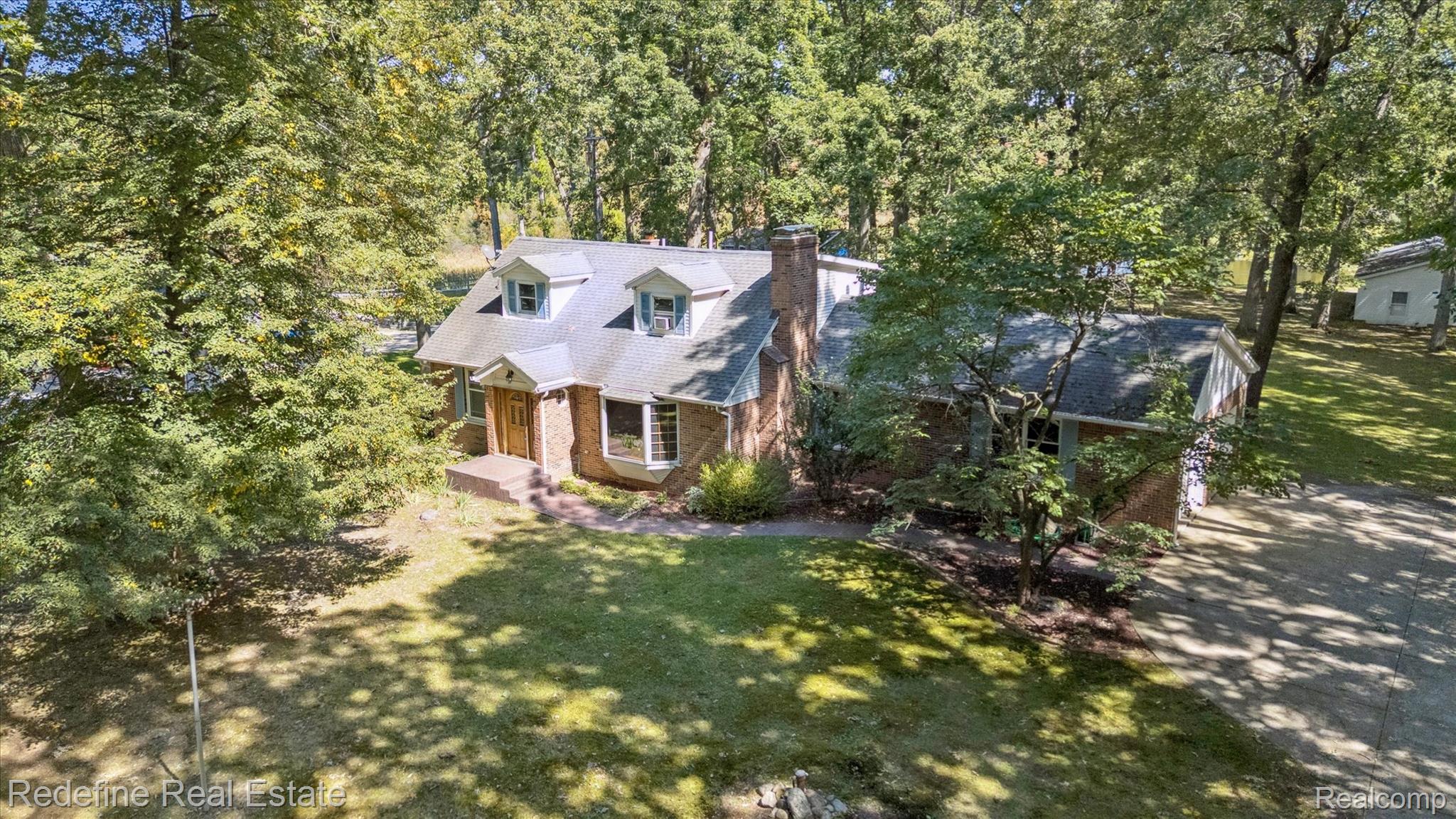 3777 Dorr Road Brighton, MI 48116 - Photo 2 of 77 View of front of house with brick siding, a chimney, and a front yard