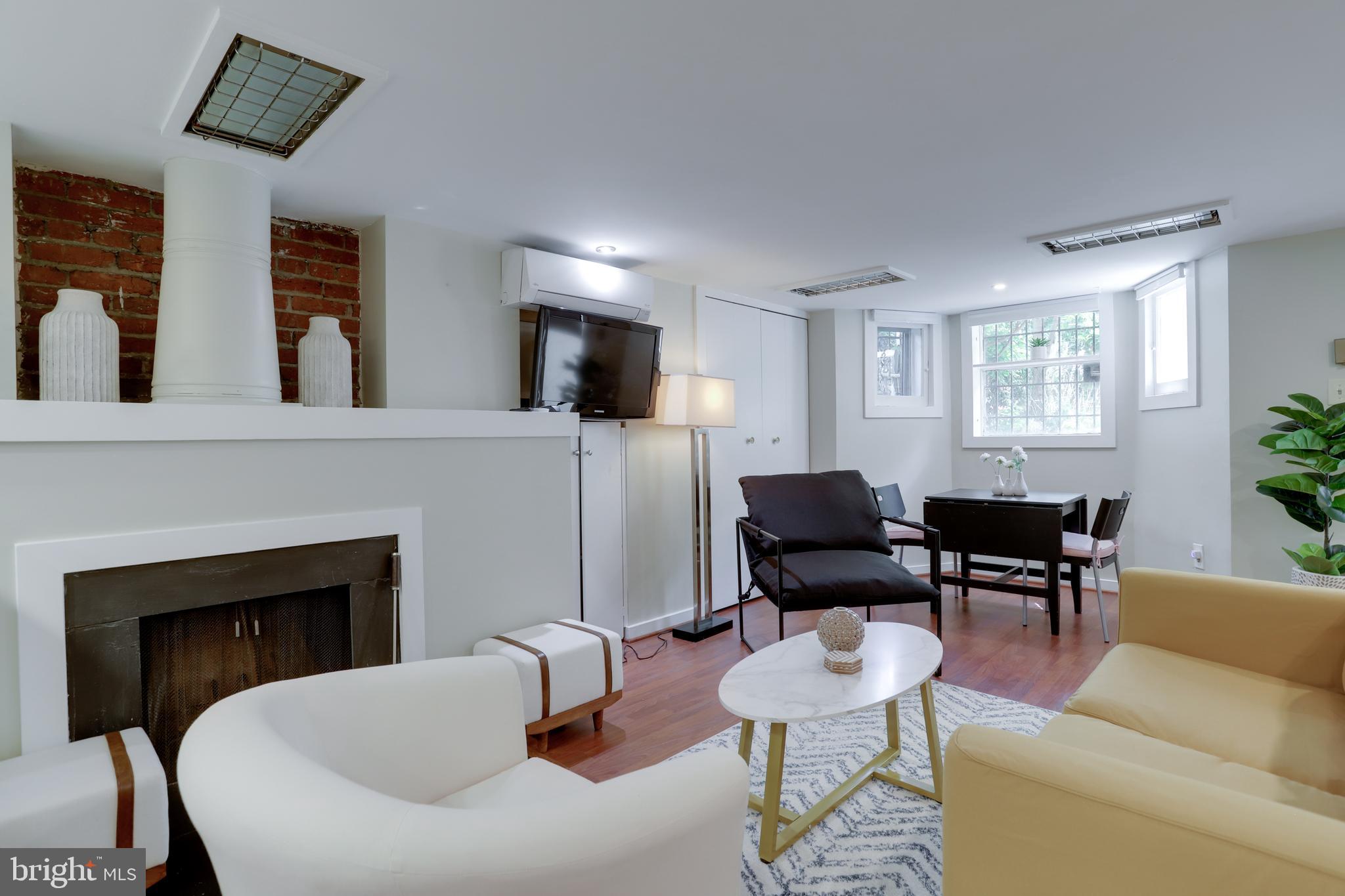 1010 Independence Avenue Southeast, Unit B Washington, DC 20003 - Photo 3 of 17 a living room with furniture a fireplace and a flat screen tv