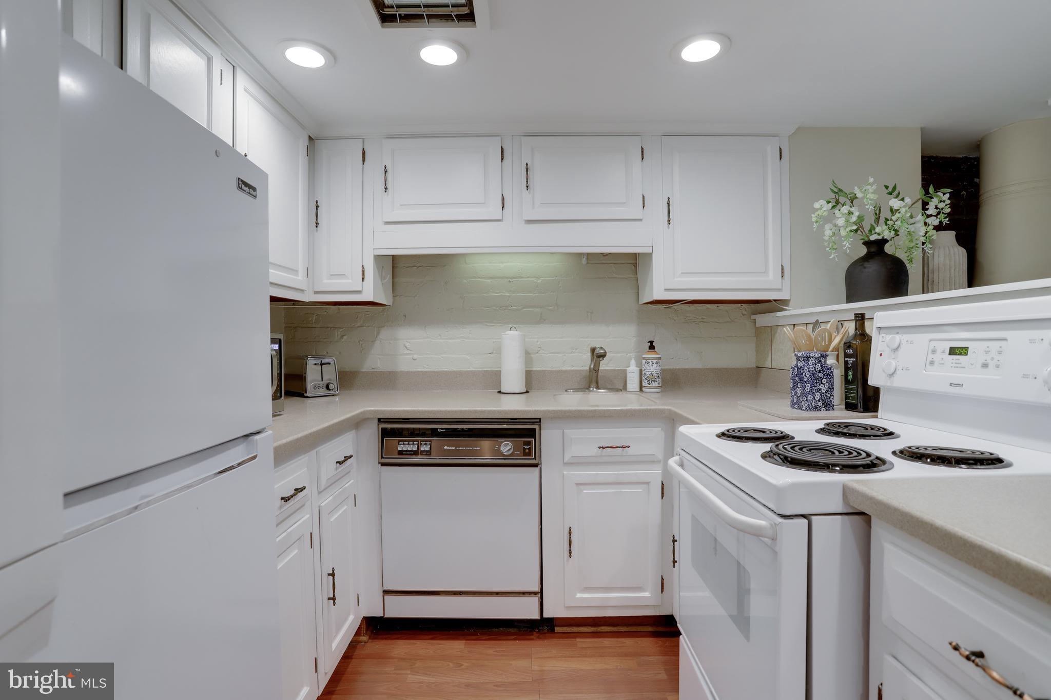1010 Independence Avenue Southeast, Unit B Washington, DC 20003 - Photo 10 of 17 a kitchen with granite countertop white cabinets and white appliances