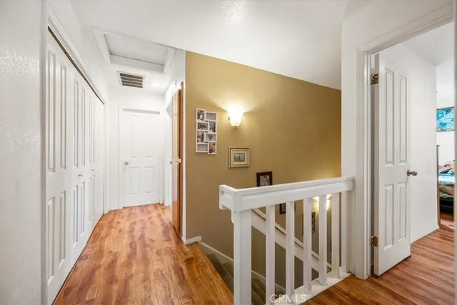 a view of a hallway with wooden floor and entryway
