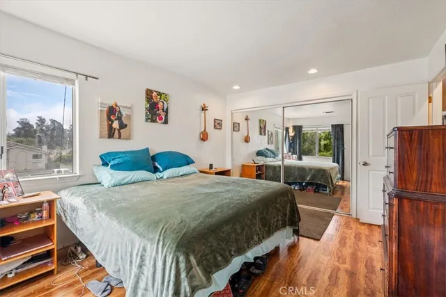 a spacious bedroom with a bed a couch and a large window