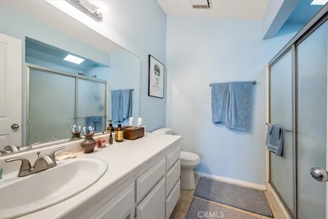 a bathroom with a double vanity sink toilet and shower