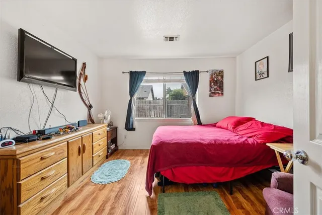 a bedroom with a bed and wooden floor