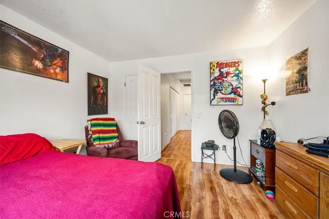 a bedroom with bed and wooden floor