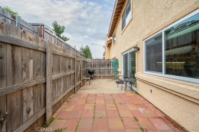 a view of a brick house with large windows and a small yard