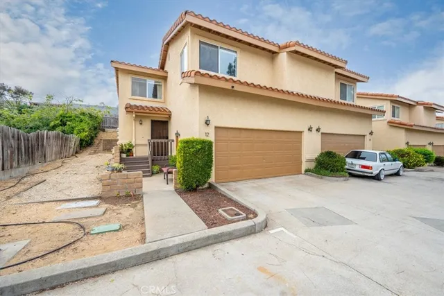 a view of a white building among the street with palm trees