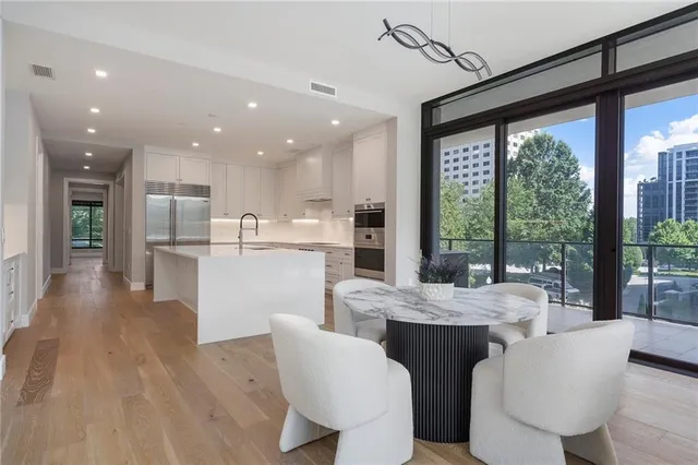 a view of a dining room with furniture a chandelier and wooden floor