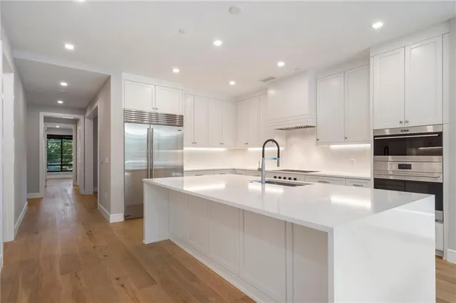 a kitchen with stainless steel appliances granite countertop a sink a stove and a refrigerator