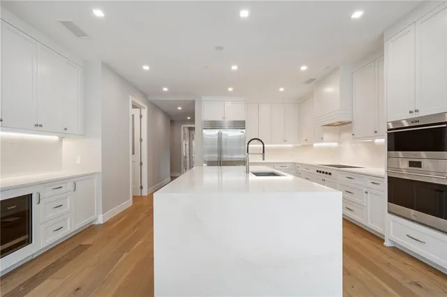 a kitchen with white cabinets appliances and sink
