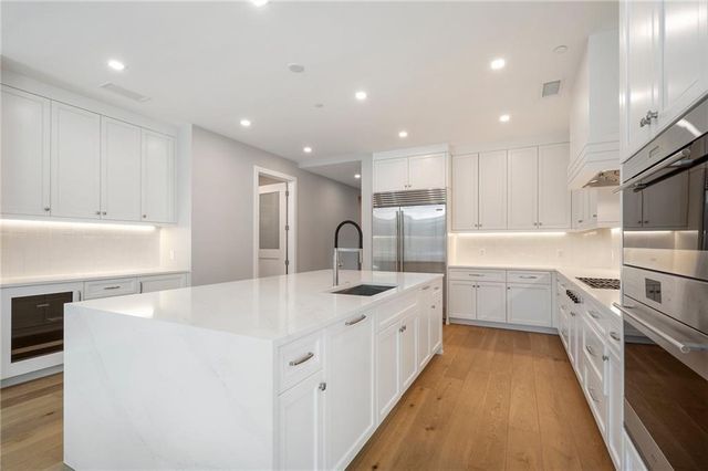 a kitchen with white cabinets appliances and sink