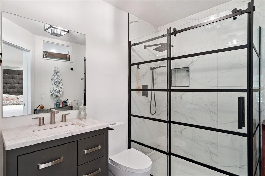 298 Lake Markham Road Sanford, FL 32771 - Photo 40 of 50 a bathroom with a granite countertop sink mirror vanity and toilet