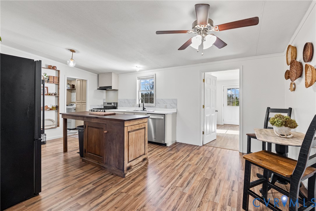 299 Arvin Store Road Keysville, VA 23947 - Photo 18 of 45 a kitchen with stainless steel appliances kitchen island granite countertop a refrigerator a stove a sink a dining table and chairs with wooden floor