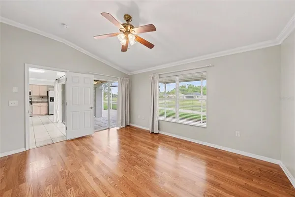 a view of an empty room with a window and wooden floor