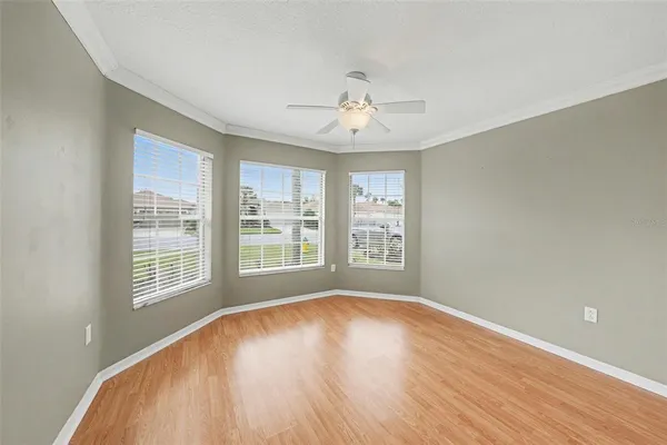 a view of an empty room with a window and wooden floor