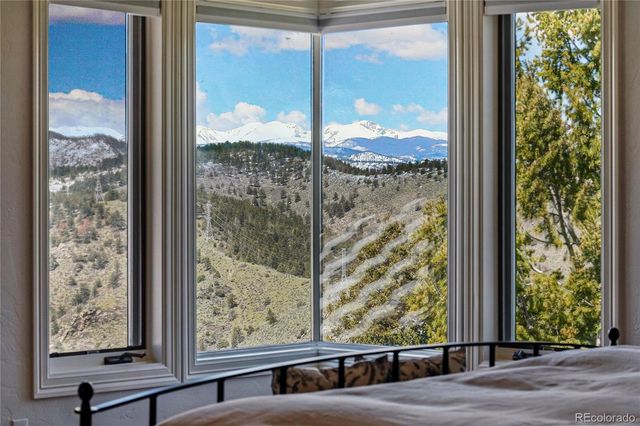 a view of a room with a large window and wooden floor