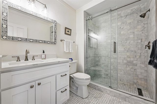 a bathroom with a shower sink vanity mirror and toilet