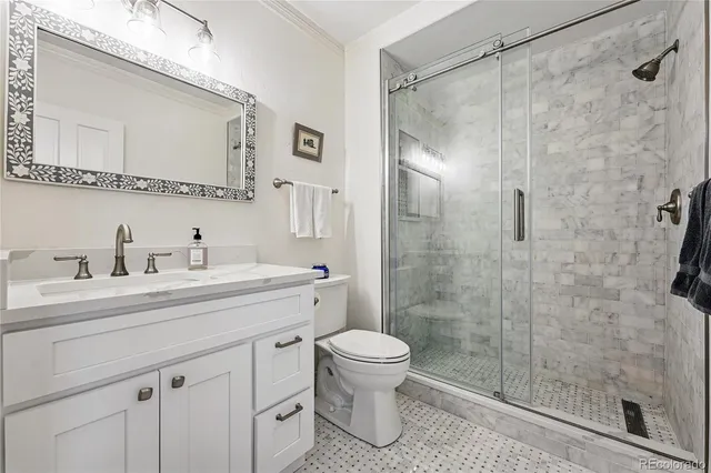 a bathroom with a shower sink vanity mirror and toilet