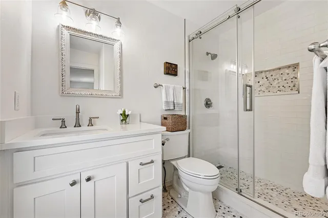 a bathroom with a sink a toilet and shower