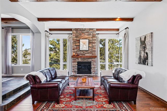 a living room with furniture large window and fireplace