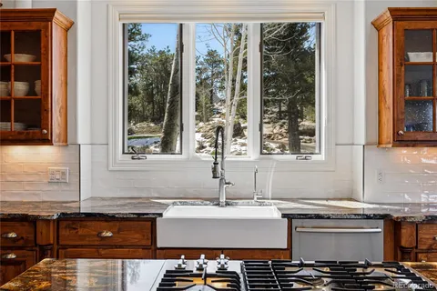 a kitchen with a sink and a stove next to a window