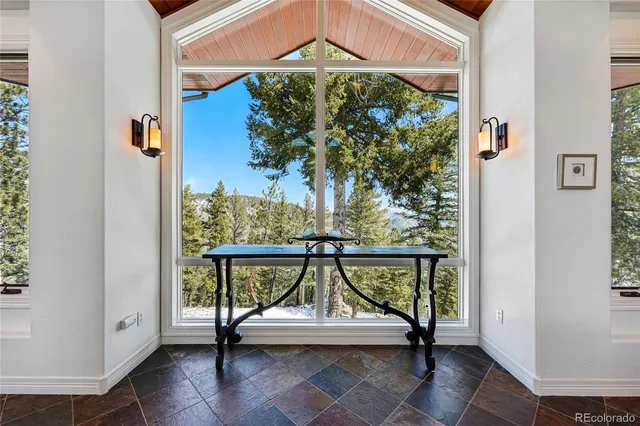 a view of a balcony with chairs and a potted plant