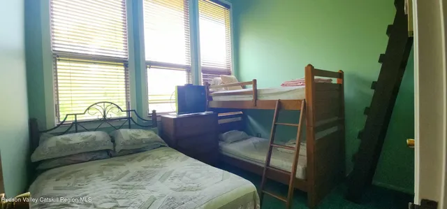 a bed sitting in a bedroom next to a window