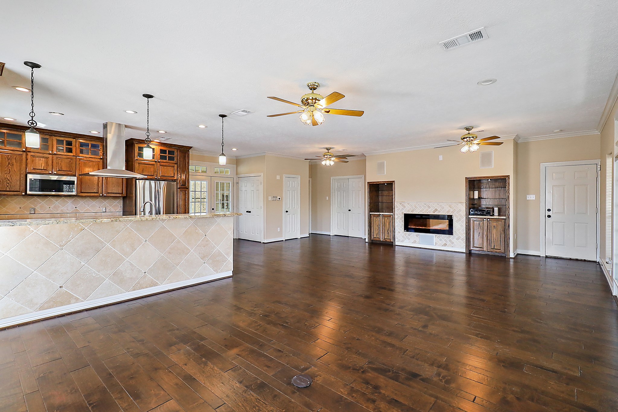1306 Spring Branch Drive Baytown, TX 77523 - Photo 33 of 38 a view of a kitchen with a kitchen island stainless steel appliances a couch wooden floor and a living room