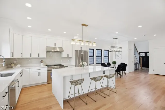 a large kitchen with kitchen island a sink table and chairs