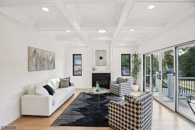 a living room with furniture a fireplace and a floor to ceiling window