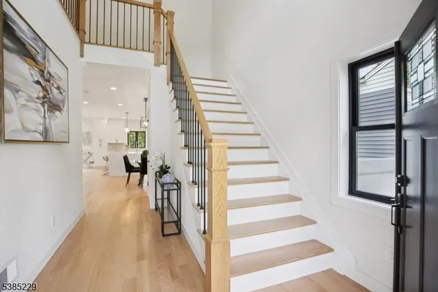 a view of a hallway with wooden floor and staircase