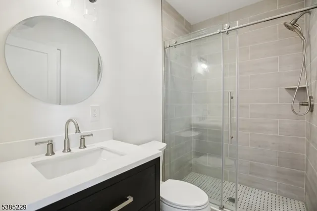 a bathroom with a sink toilet a mirror and shower