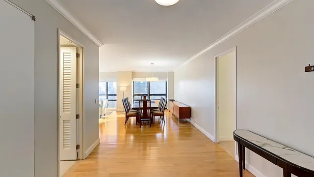 a view of a dining room with furniture a rug and wooden floor