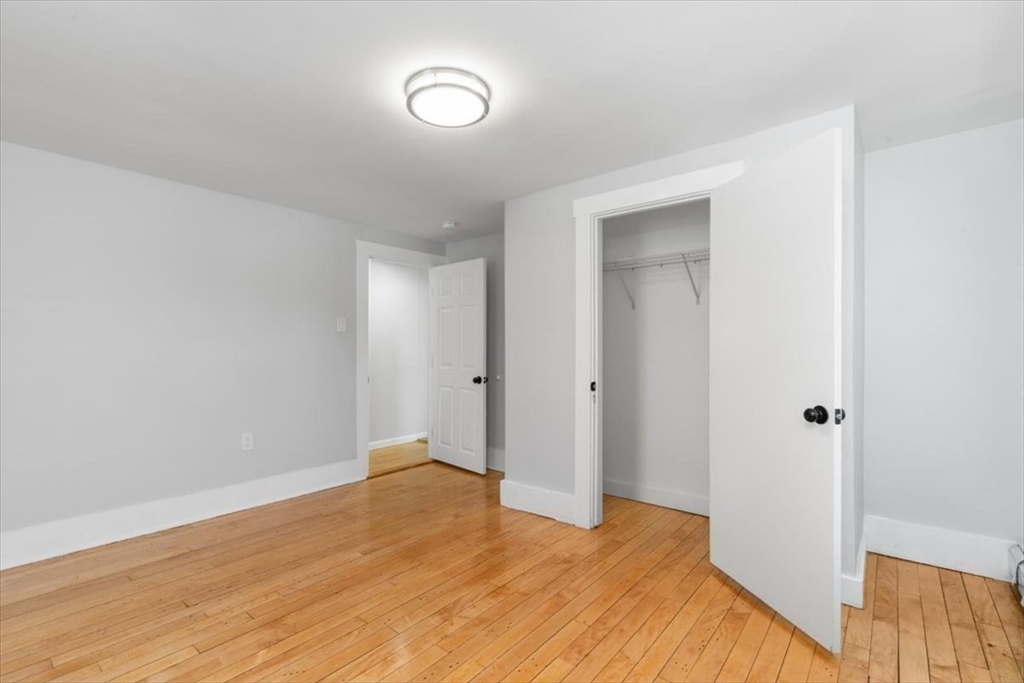 129 Friend Street, Unit 2 Amesbury, MA 01913 - Photo 12 of 27 a big room with wooden floor and bathroom view