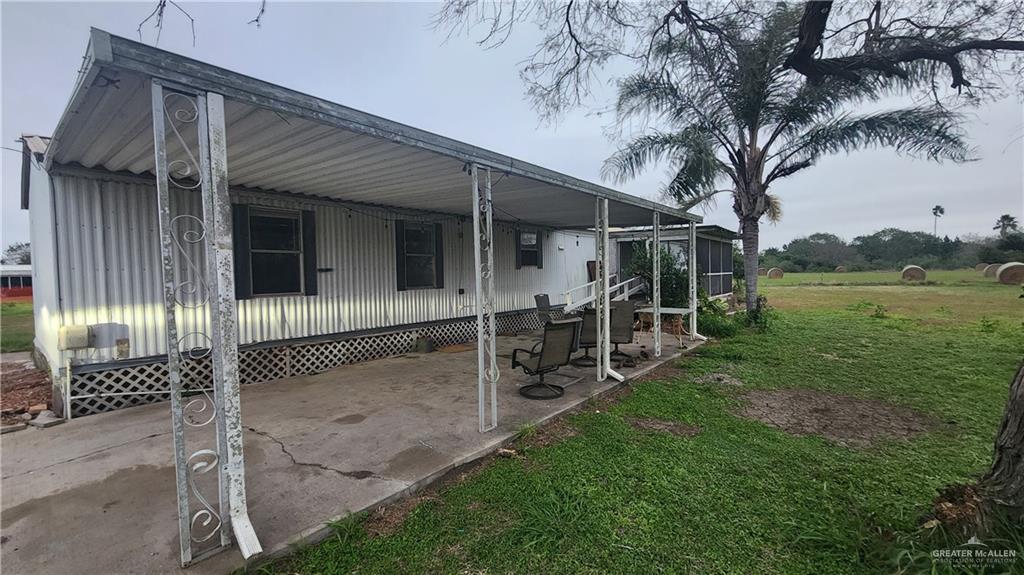 32656 San Carlos Road, Unit 2 Los Fresnos, TX 78566 - Photo 7 of 15 a white house with a large tree and a yard in front of it
