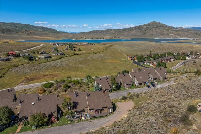 an aerial view of ocean and residential houses with outdoor space