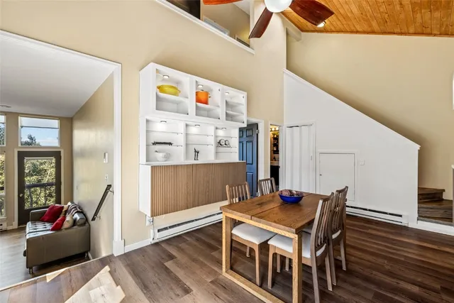 a living room with table chairs and wooden floor
