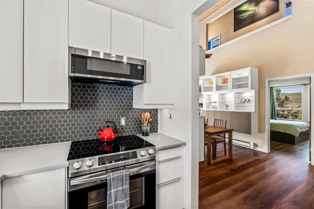a kitchen with stainless steel appliances a stove a sink and a microwave