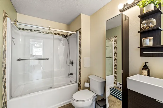 a bathroom with a toilet a sink and shower